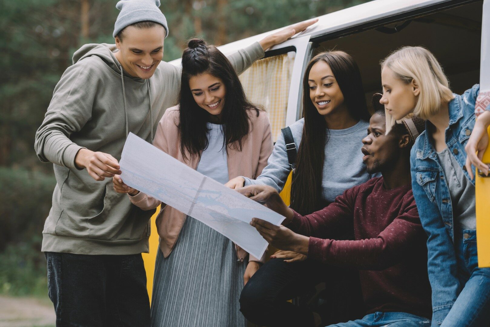Groep vrienden op zoek naar kaart tijdens hun roadtrip