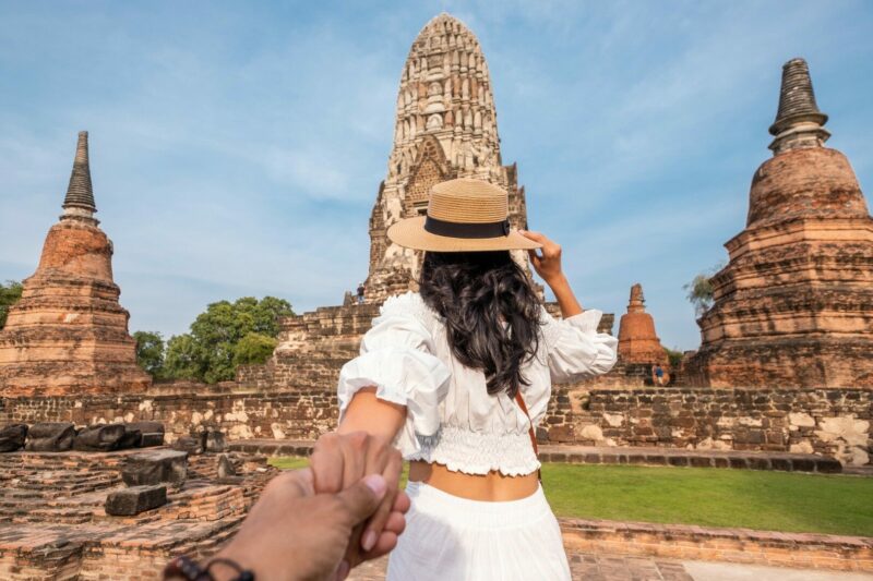 Woman holding a hands man when visiting asian touristic place of Ayuthaya. Follow me in Thailand. Couple in holidays