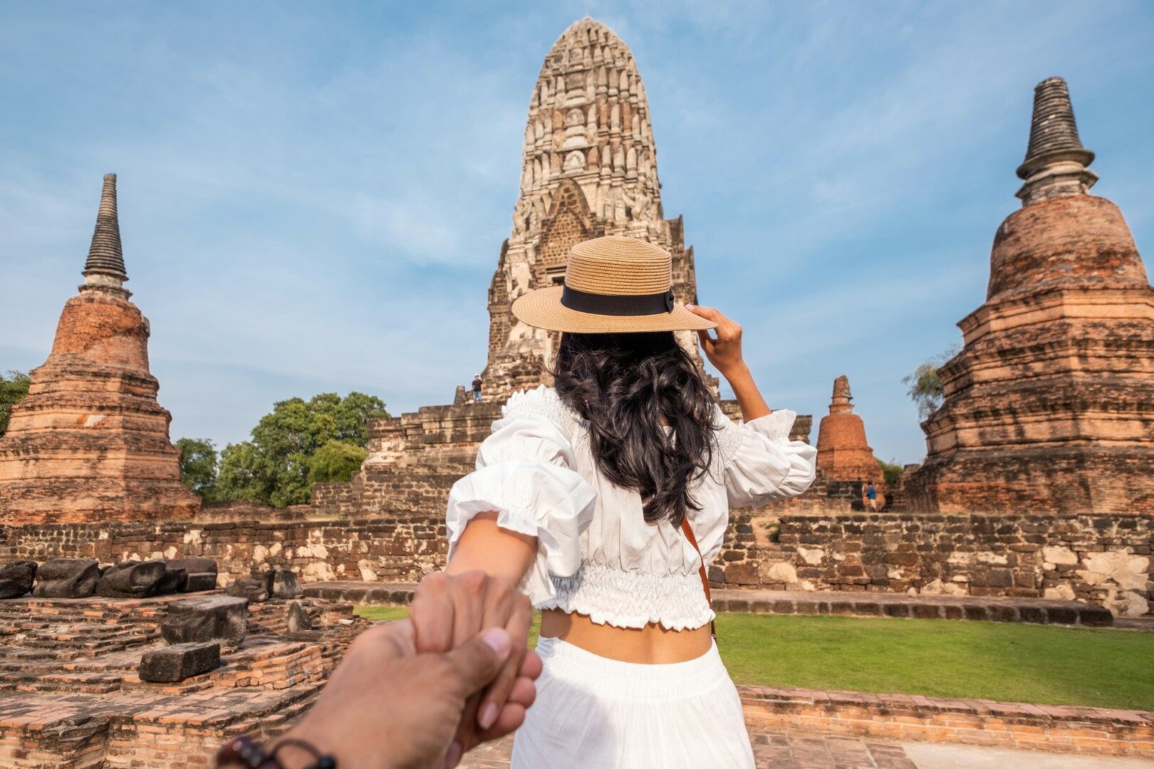 Woman holding a hands man when visiting asian touristic place of Ayuthaya. Follow me in Thailand. Couple in holidays